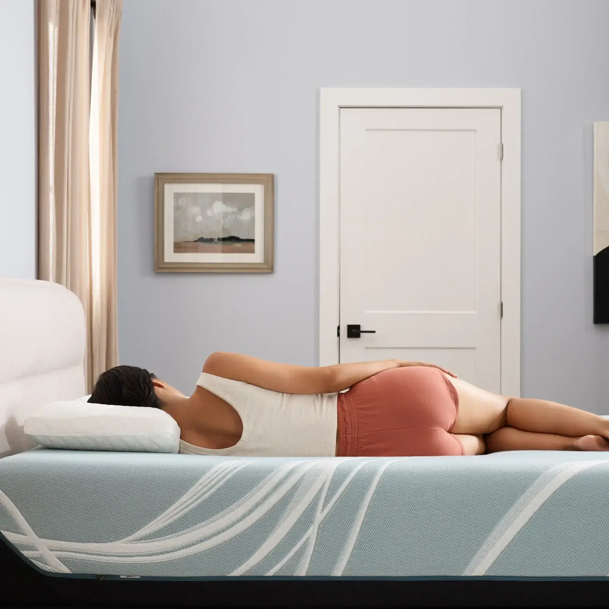 Woman sleeping on a Tempur-Pedic TEMPUR-LuxeAdapt® 13" Firm Mattress, showcasing comfort and support in a serene bedroom setting.