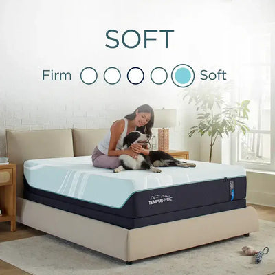 Woman relaxing on a Tempur-Pedic TEMPUR-LuxeAdapt Soft 13" mattress with a dog, showcasing the mattress's comfort level.