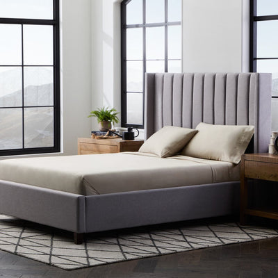 Cozy bedroom featuring a Malouf bamboo rayon sheet set on a stylish gray bed with modern decor.