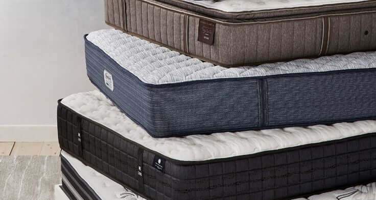 Stacked mattresses in various colors and textures, showcasing a range of comfort options for better sleep.