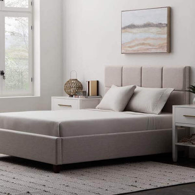Cozy bedroom scene featuring a bed with Malouf Driftwood Soft Knit Microfiber Sheet Set and modern decor elements.