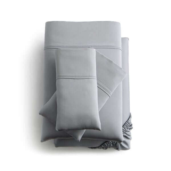 Gray Malouf Botanical Tencel™ Lyocell Sheet Set featuring pillowcases, flat and fitted sheets stacked neatly.
