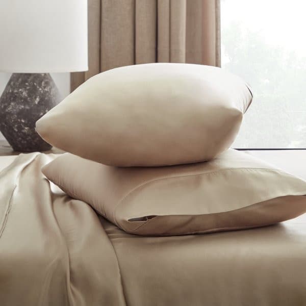 Two soft, beige pillows on a smooth Tencel™ Lyocell sheet set, showcasing luxurious bedding and eco-friendly materials.
