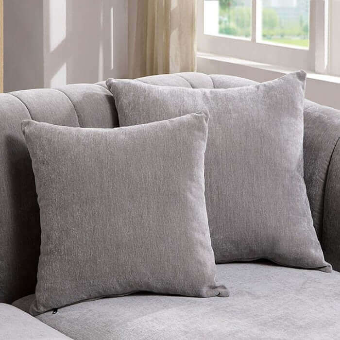 Two soft gray decorative pillows on a light gray sofa, adding comfort and style to the living room.