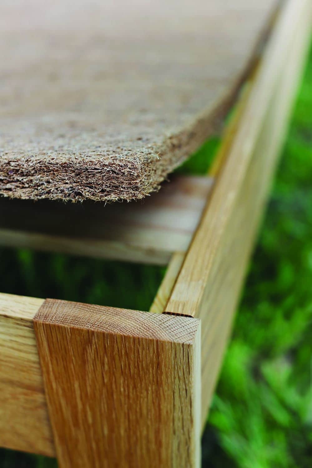 Close-up of Queen Savvy Rest natural coconut fiber mattress rug on a wooden platform bed, showcasing airflow design.