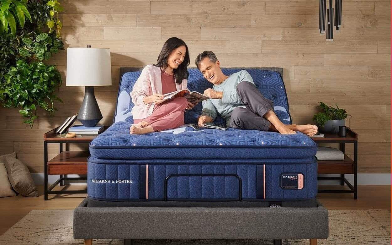 Couple enjoying a cozy moment on the Stearns & Foster Lux Estate® Firm Pillow Top 16" Mattress in a stylish bedroom setting.