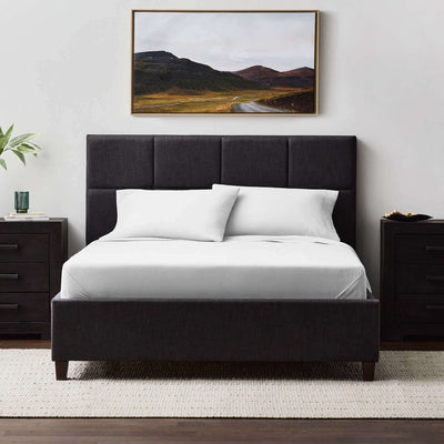 Modern bed with black upholstered headboard and Malouf Fog Linen Weave Cotton Sheet Set, framed landscape art on the wall.