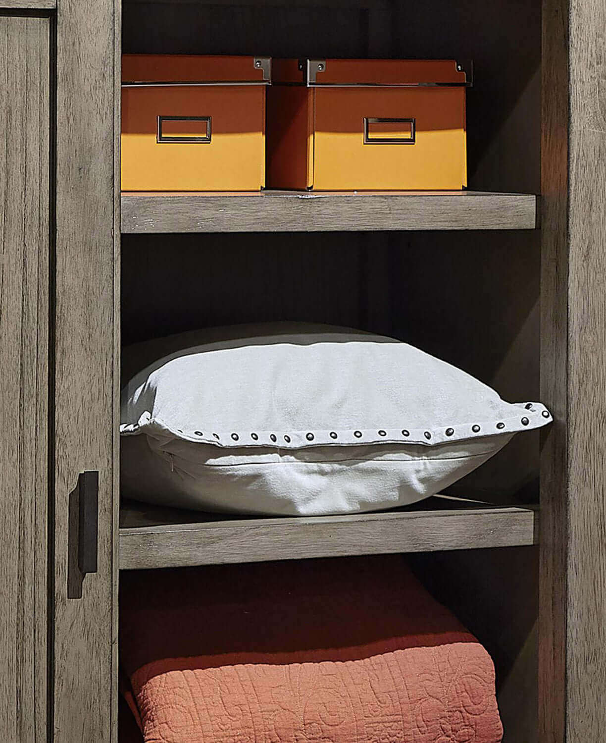 Graystone sliding door chest showcasing neatly organized storage with colorful boxes and decorative pillows.