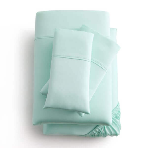 Soft mint green Malouf Botanical Tencel™ Lyocell sheet set with pillowcases and fitted sheet displayed neatly.