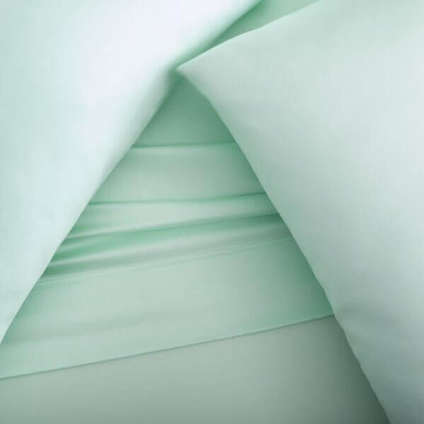 Soft mint green Tencel™ Lyocell sheets and pillowcases showcasing their smooth, eco-friendly fabric and luxurious comfort.