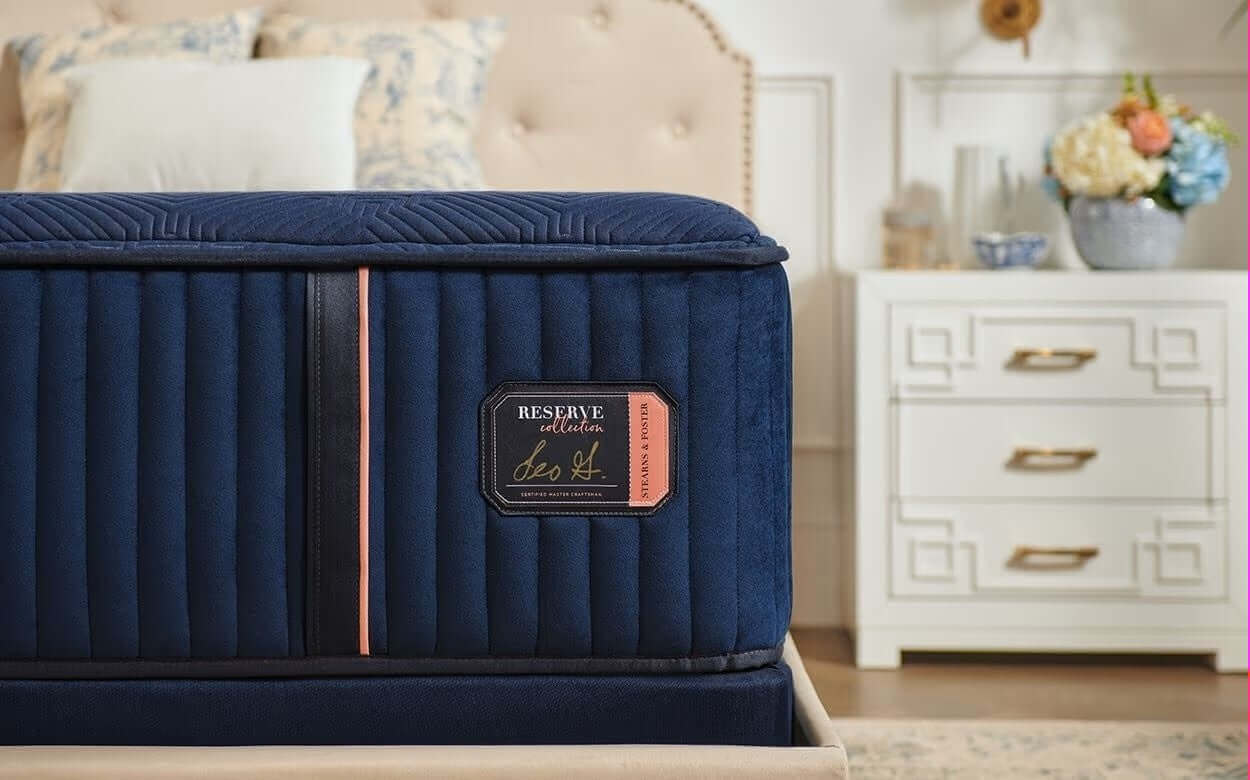 Stearns & Foster Reserve® Medium 16" Mattress showcasing elegant navy upholstery and luxury branding detail.