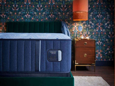 Stearns & Foster Estate® Extra Firm 13.5" Mattress displayed in a stylish bedroom setting with floral wallpaper.