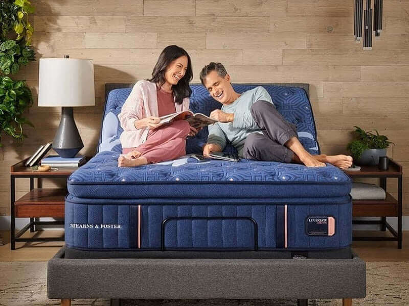Couple enjoying time together on a Stearns & Foster Lux Estate® Firm Pillow Top Mattress in a stylish bedroom setting.
