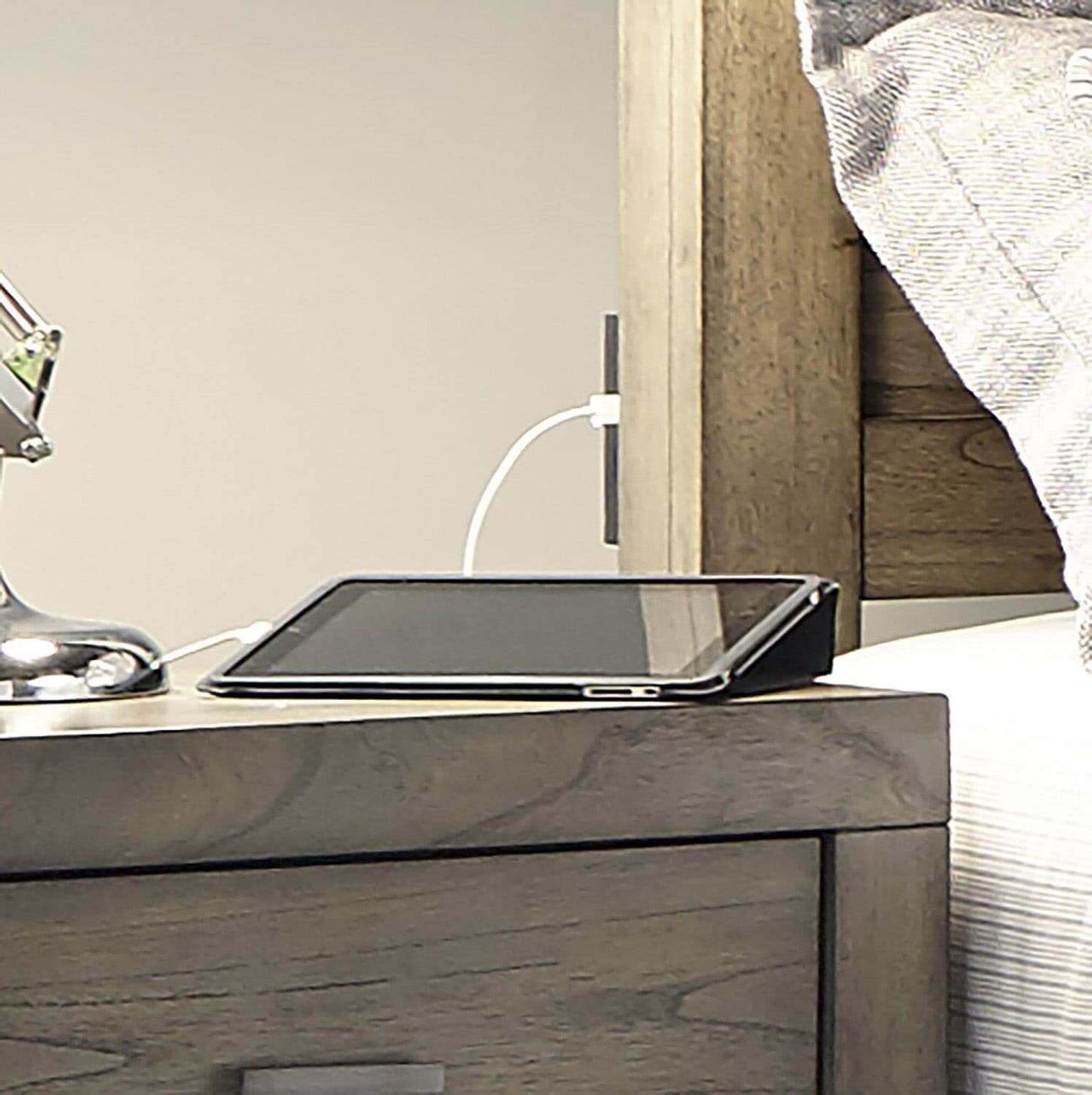 Graystone platform panel bed nightstand with tablet and lamp, showcasing modern loft collection's sleek design.