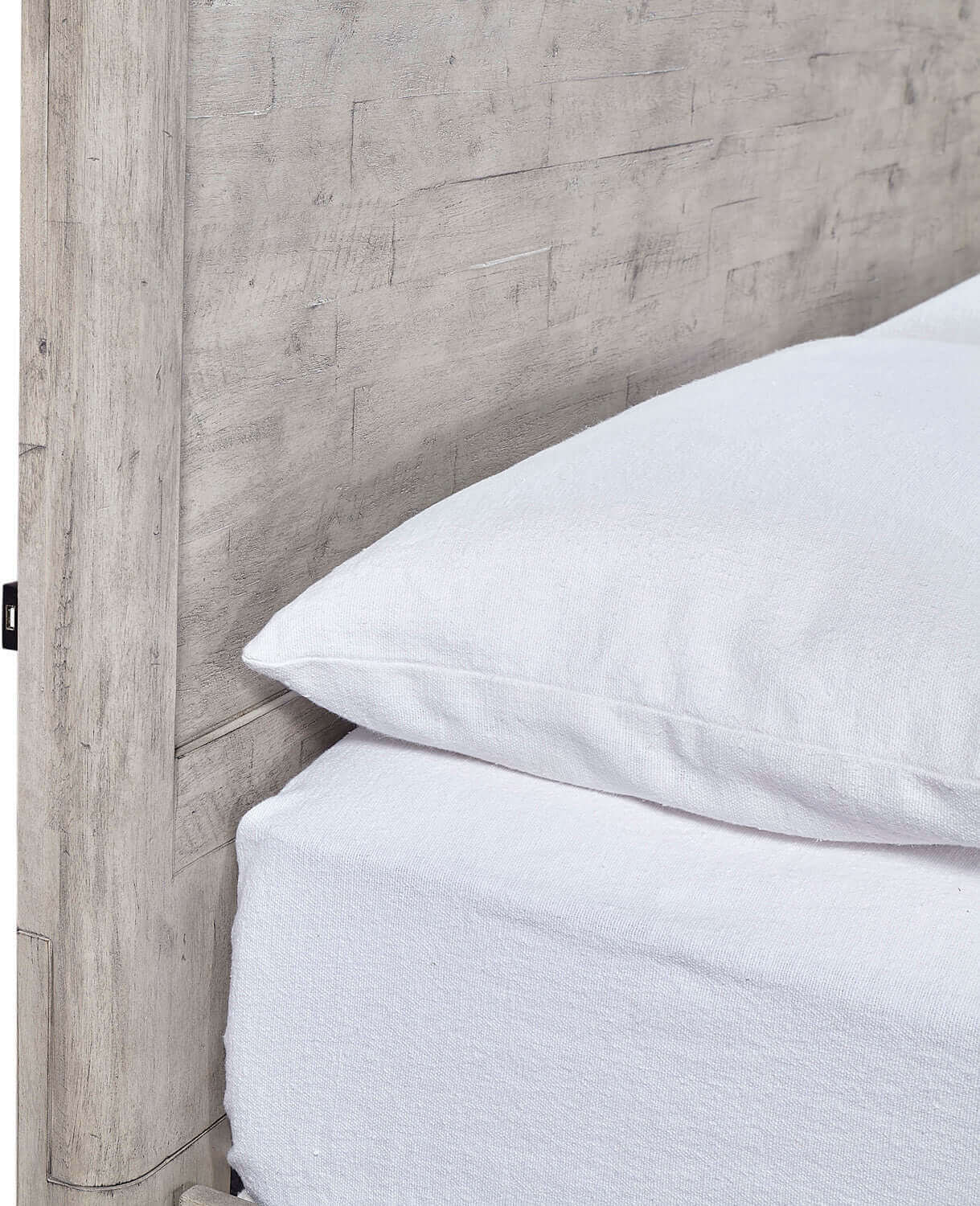 Close-up of Zane Collection Panel Bed's textured headboard and soft white bedding, showcasing quality craftsmanship.