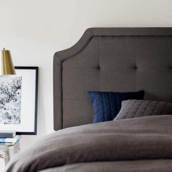 Malouf Carlisle charcoal gray headboard with tufted upholstery and modern design in cozy bedroom setting.
