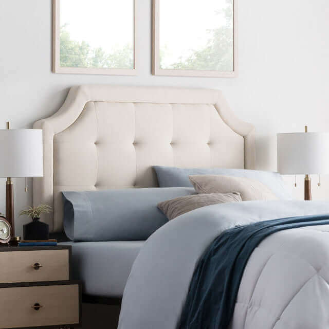 Malouf Carlisle Oat Beige Headboard with tufted upholstery in a modern bedroom setting featuring bedside lamps.