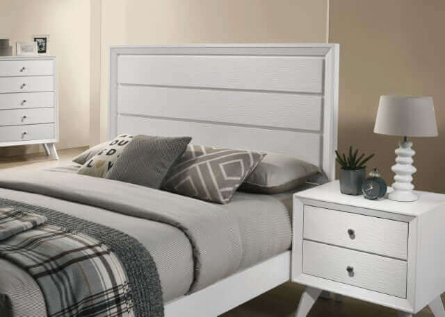 Modern Dortmund White Panel Bed with textured headboard, paired with nightstand and stylish decor in minimalist bedroom setting.