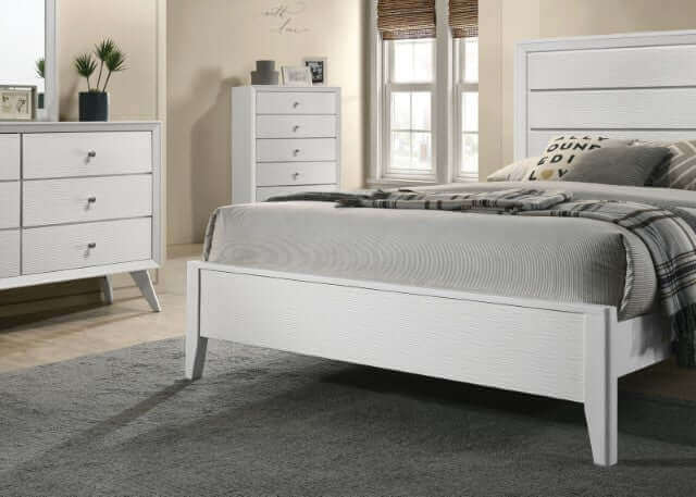 Modern Dortmund White Panel Bed featuring wave-textured headboard, footboard, and matching furniture in a stylish bedroom setting.