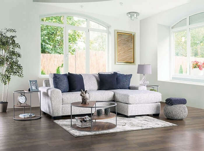 Eastcote Gray Sectional Sofa in stylish living room with natural light, featuring accent pillows and chic decor elements.