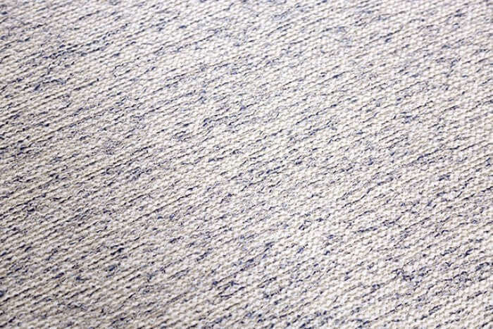 close-up view of textured soft carpet with a beige and navy blue pattern, suitable for interior decor.