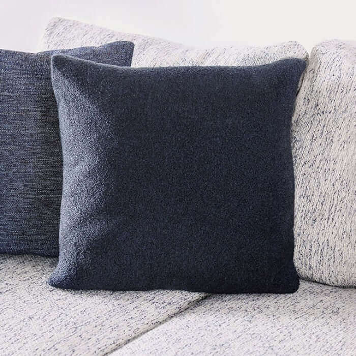 Dark gray decorative pillow on a light gray sectional sofa, adding comfort and style to the living room.