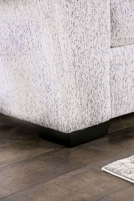 Close-up of Eastcote Gray Sectional Sofa's textured upholstery and tapered legs on a wooden floor.
