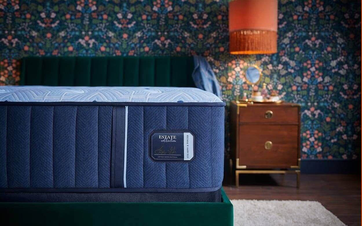 Stearns & Foster Estate Plush 14.5" Mattress showcased in a stylish bedroom with floral wallpaper and modern decor.