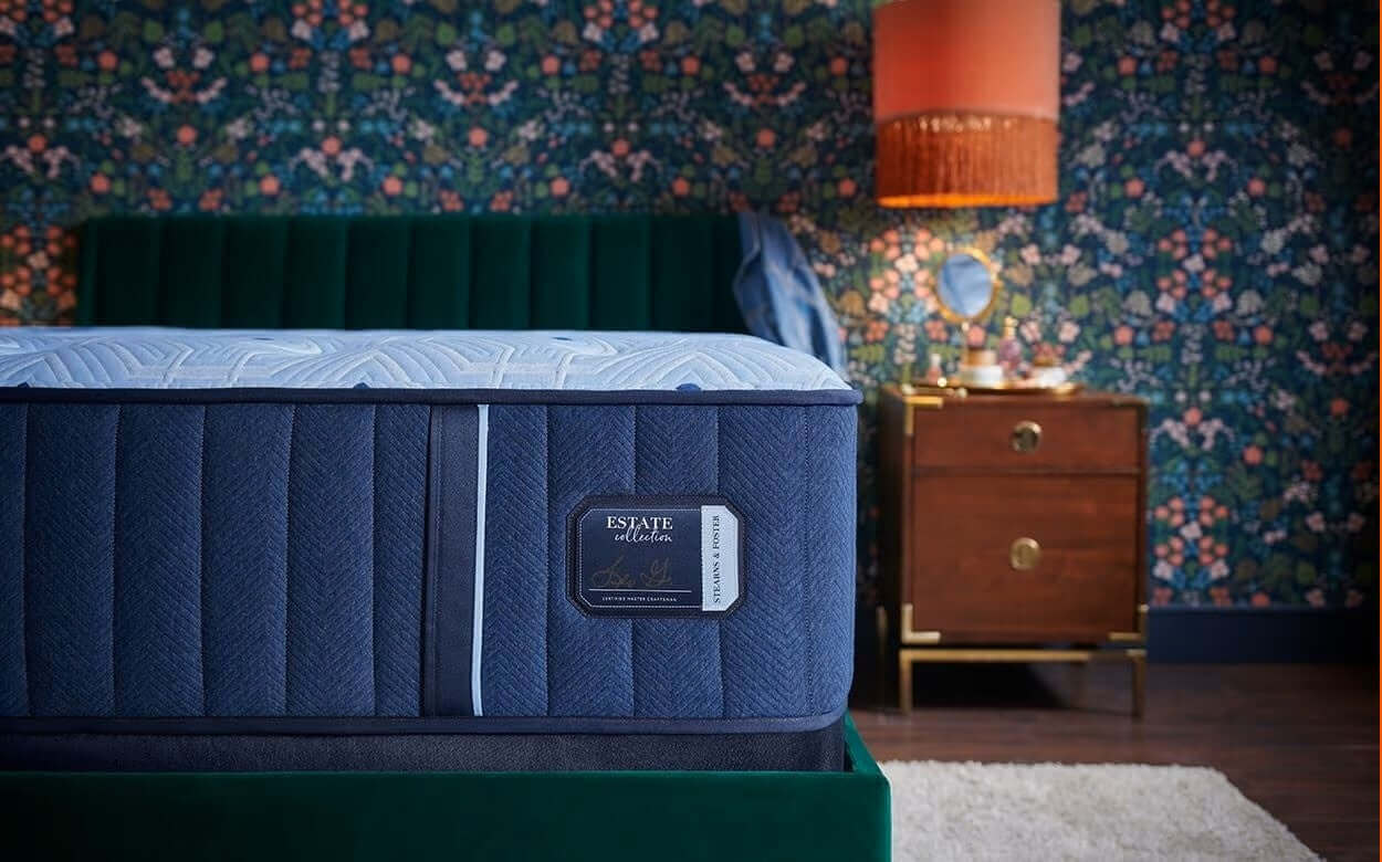 Stearns & Foster Estate Extra Firm 13.5" mattress showcased in a stylish bedroom setting with floral wallpaper.