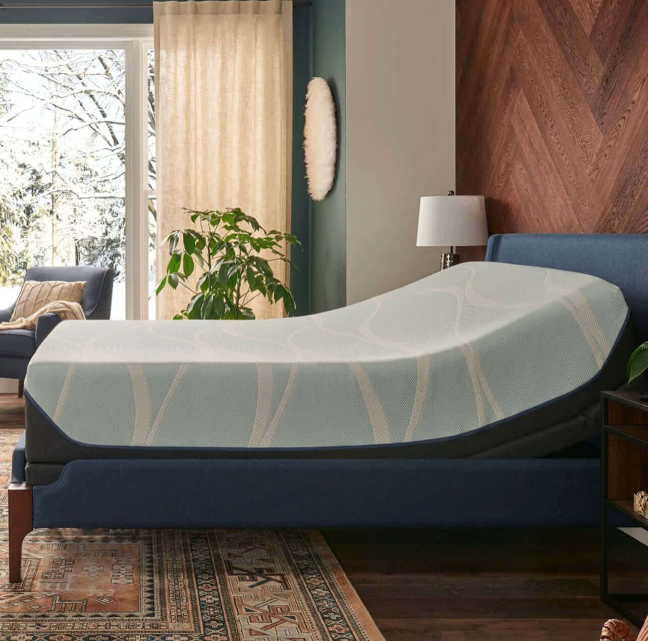 Tempur-Pedic TEMPUR-Ease adjustable base elevated in a cozy, modern bedroom setting with natural light.