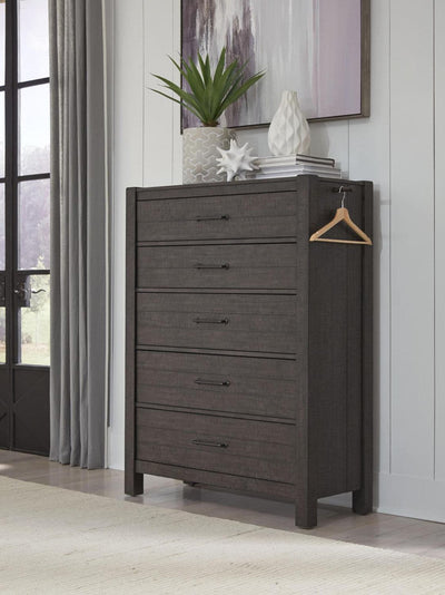 Mill Creek Collection Carob Chest featuring five drawers, a modern design, and decorative plant accents in a stylish home setting.