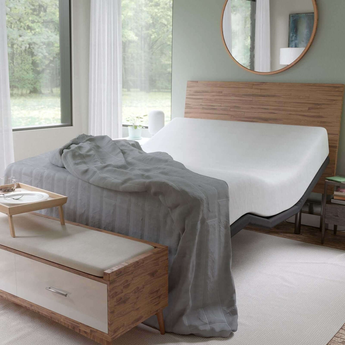 Reverie R400 adjustable power base in a modern bedroom with gray blanket and wooden furniture.