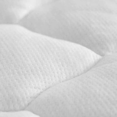 Close-up of a plush white mattress pad with quilted texture, highlighting breathable bamboo-rayon material.