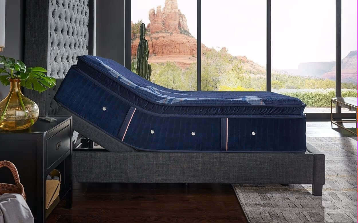 Stearns & Foster Reserve® 17" Firm Pillow Top Mattress adjustable base in modern bedroom setting with scenic view.