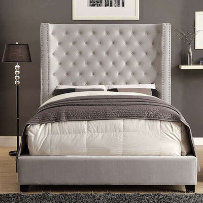 Grey tufted wingback bed with nailhead trim and a cozy bedding setup, perfect for any bedroom style.