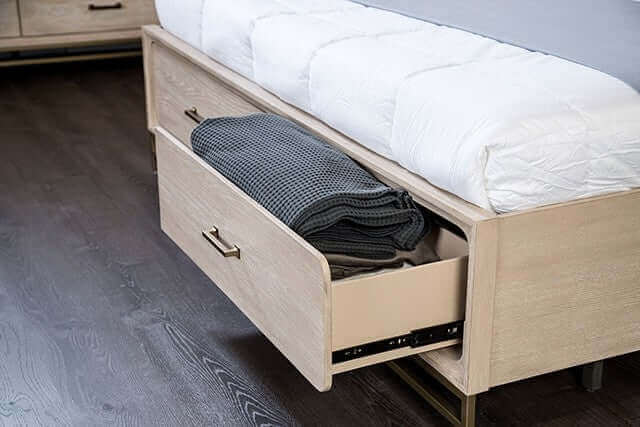 Storage drawer under the Sandnes Light Oak Mid Century Bed Frame, showcasing blankets in a modern bedroom setting.