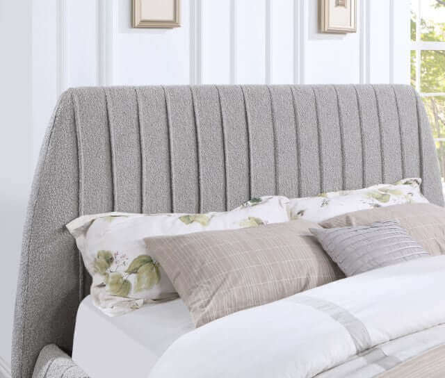 Sherise Bed with gray boucle upholstered headboard featuring sophisticated vertical pleating and cozy pillows.