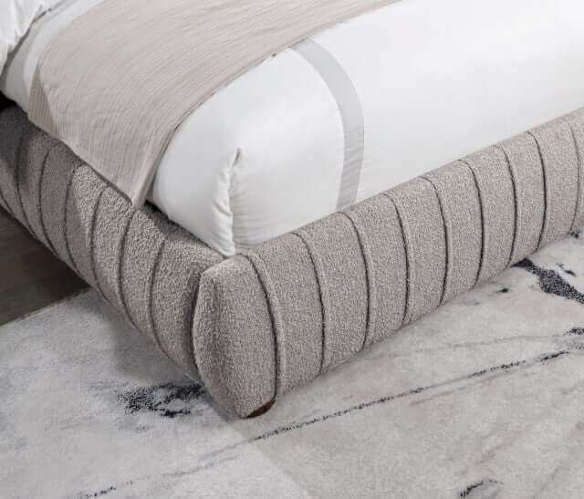 Contemporary Sherise Bed upholstered in boucle fabric with ridged pleating, showcasing a gray, textured design on a stylish rug.