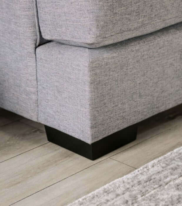 Corner detail of Skyline Gray Loveseat showcasing soft fabric and sturdy wood legs on a stylish floor.