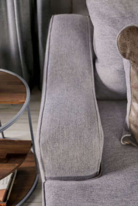 Skyline Gray Loveseat armrest showcasing soft fabric and welt trim detailing in a modern living room setting.