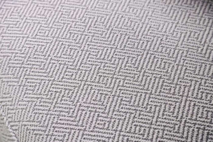 Close-up of a textured pewter gray fabric featuring an intricate geometric pattern, ideal for modern and transitional furniture.