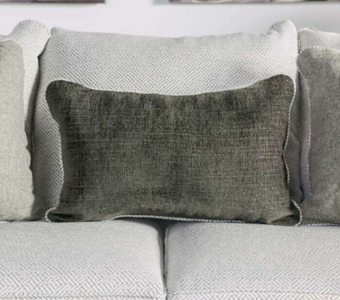 Decorative muted dark throw pillow on a cozy gray sofa, enhancing comfort and style in a living room setting.