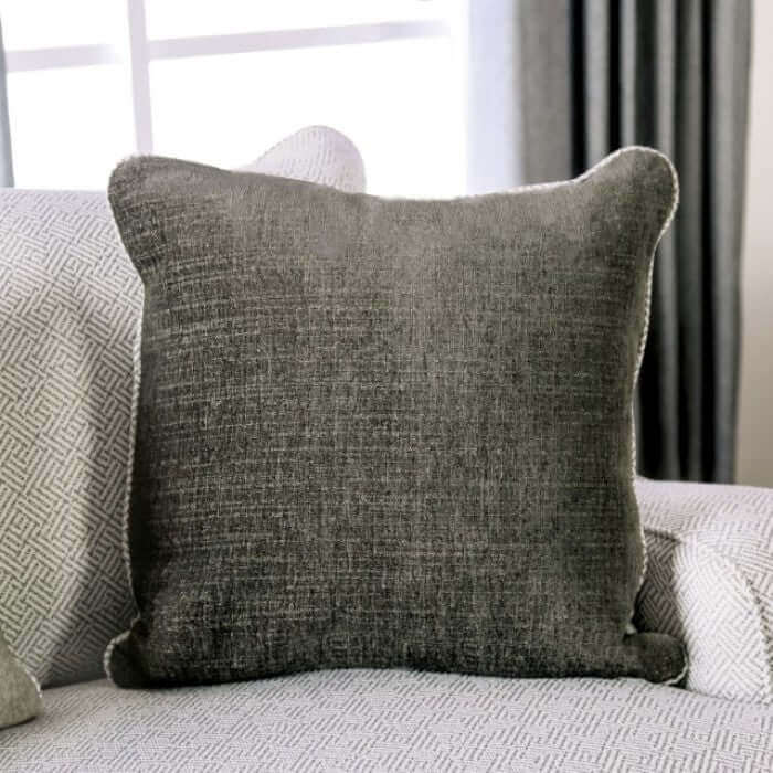 Soft gray throw pillow resting on a textured sofa, adding a cozy touch to modern living room decor.