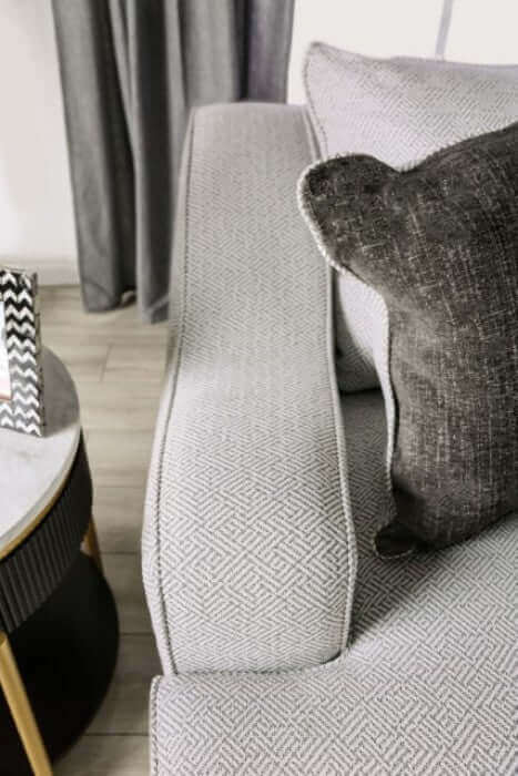 Close-up of Skyline Pewter Gray sofa arm and textured throw pillow on a stylish living room setting.