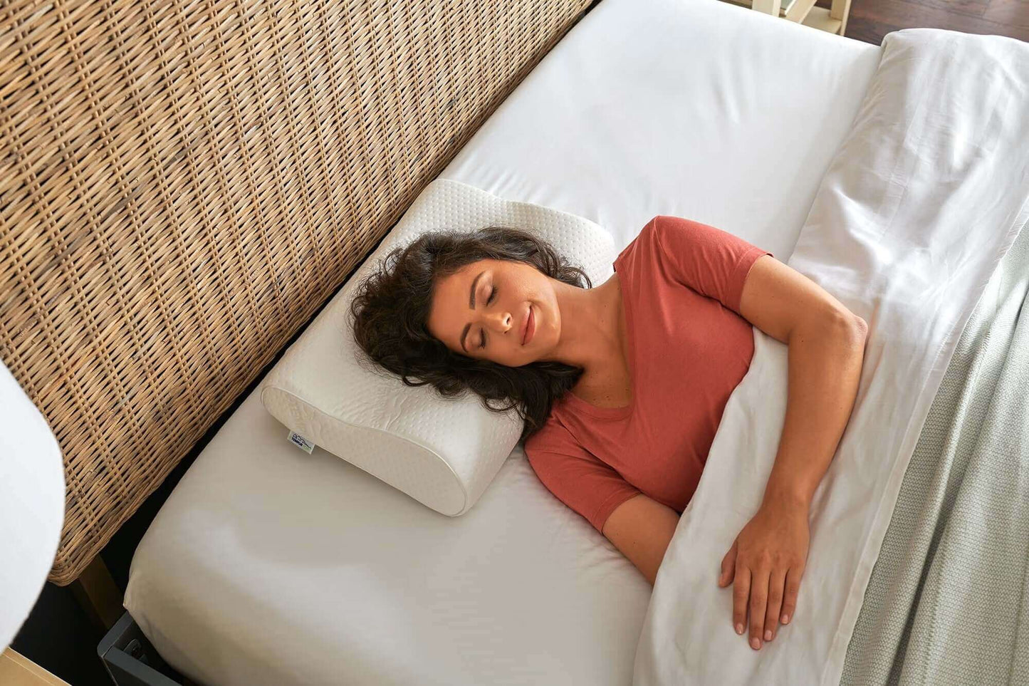 Woman peacefully sleeping on a Tempur-Pedic Tempur-Neck Firm Pillow, showcasing comfort and support.