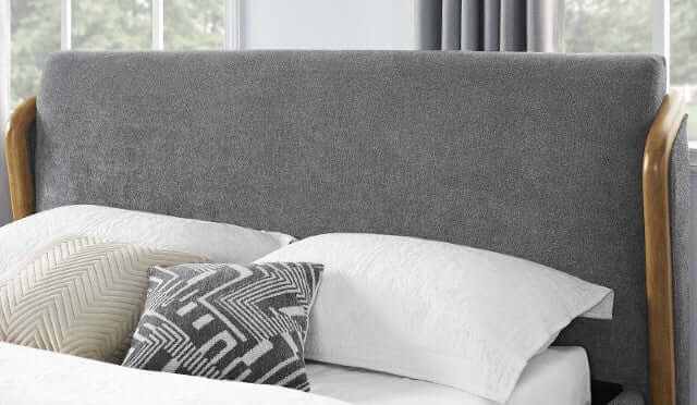 Ulstein Mid Century Platform Bed gray upholstered headboard with wooden frame and decorative pillows on a white bed.