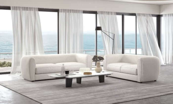 Verdal Off White Contemporary Armchair in a modern living room with ocean view and light curtains.