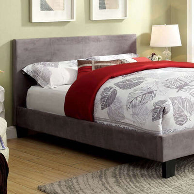 Contemporary gray upholstered platform bed with padded headboard and slat kit, styled with red bedding and modern décor.