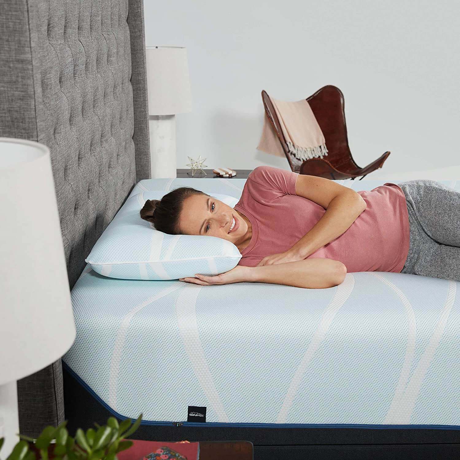 woman relaxing on a Tempur-Breeze° ProLo pillow on a mattress, showcasing cooling comfort and support for restful sleep.