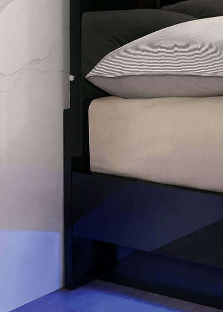 Close-up of Erlach Black Gloss LED Platform Bed showcasing ambient lighting and luxurious bedding.